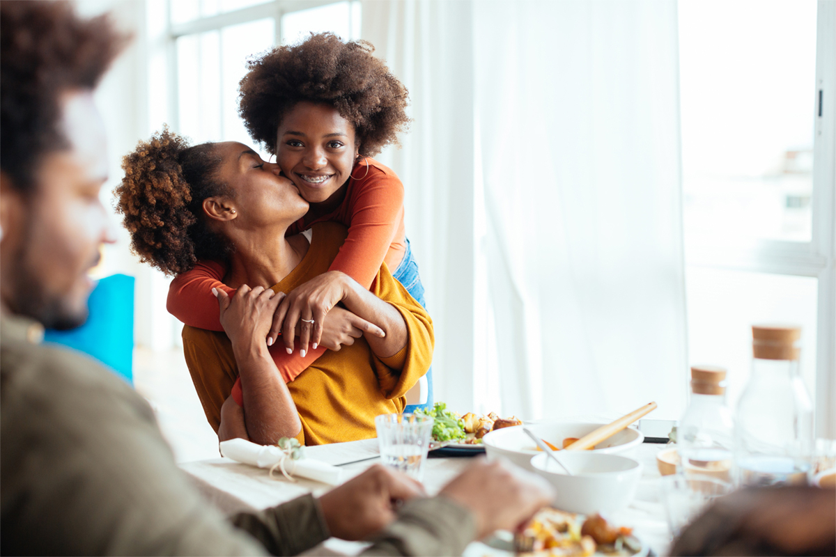 Mom and daughter embracing at dinner table